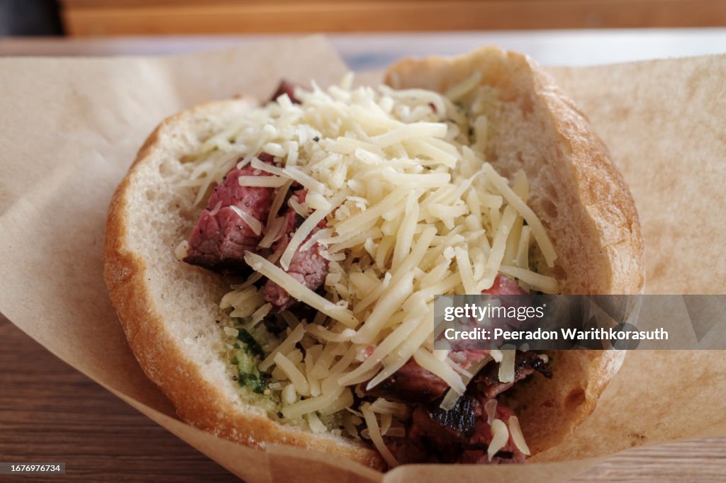 Beef sandwich on top with Cheddar cheese.