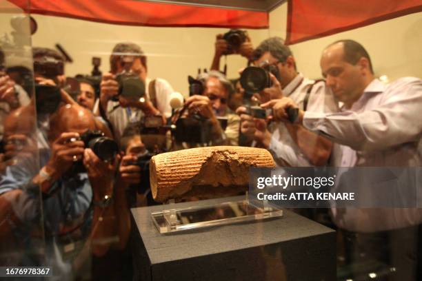 Photographers are seen at the unveiling on the Cyrus Cylinder, at the National Museum of Iran in Tehran on September 12, 2010. The artefact dating...