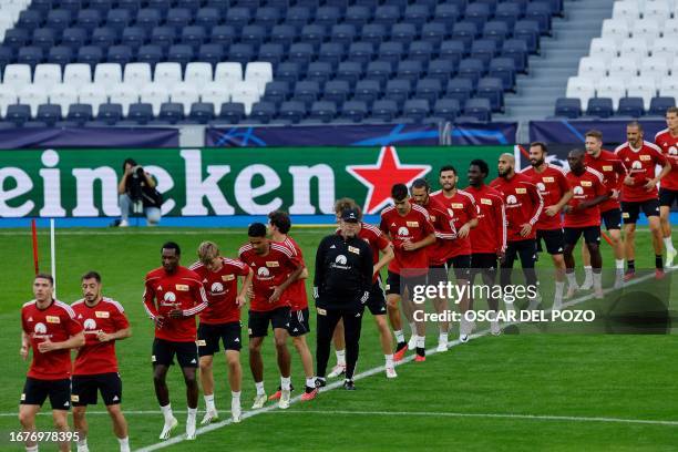 Union Berlin's Swiss head coach Urs Fischer and his players attend a training session on the eve of the UEFA Champions League football match between...