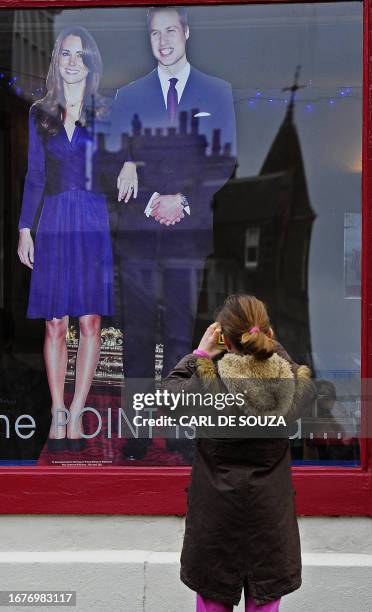 Girl takes a picture of a cardboard cut-out depicting Britain's Prince William and his fiancee Kate Middleton outside the Northpoint cafe, where they...