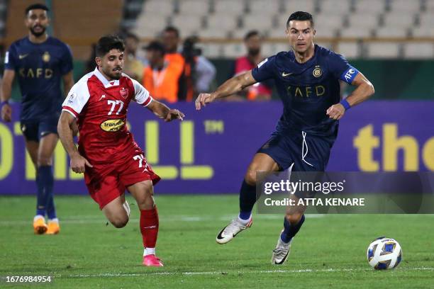 Nassr's Portuguese forward Cristiano Ronaldo and Persepolis' Iranian midfielder Mohammad Omri vie for the ball during the AFC Champions League group...