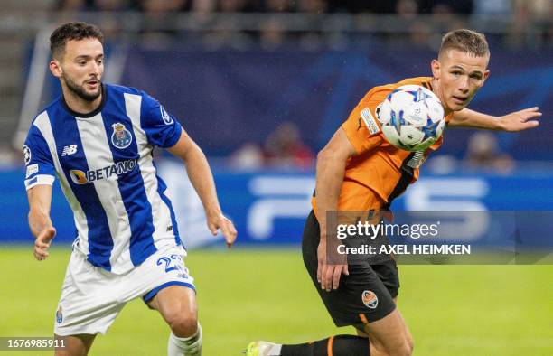 Porto's Portuguese defender Joao Mario and Shakhtar Donetsk's Ukrainian forward Danylo Sikan vie for the ball during the UEFA Champions League Group...