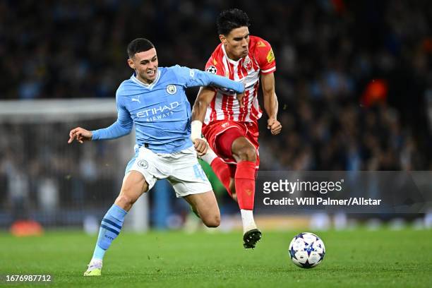 Phil Foden of Manchester City and Marko Stamenic of Crvena zvezda challenge during the UEFA Champions League Group G match between Manchester City...