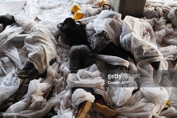 Bangladeshi volunteers sleep before they conduct rescue operations in the Rana Plaza garment building that collapsed in Savar, on the outskirts of...