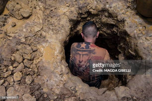Venezuelan miner wearing a shirt with the image of "Uncle Sam" works digging in a mine to extract gold, which will then be sold in El Callao, Bolivar...