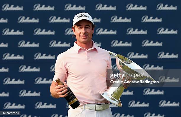 Brett Rumford of Australia poses with the trophy and a bottle of Ballantine's whisky after winning the Ballantine's Championship at Blackstone Golf...