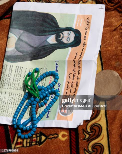 Shiite Muslim publication with a depiction of the Imam Ali , the cousin of Islam's prophet Mohammed, a set of blue prayer beads, and a clay tablet...