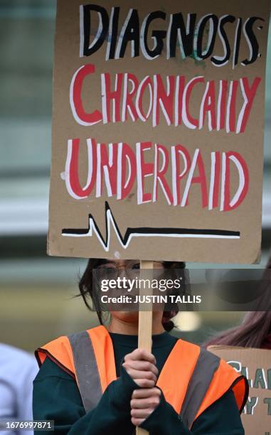 National Health Service worker holds a placard at a picket line outside University College Hospital in central London on September 20, 2023 as...