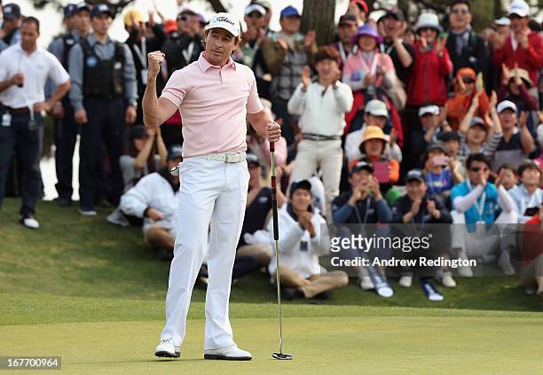 Brett Rumford of Australia celebrates after holing an eagle putt at the first play-off hole to win the play-off and the Ballantine's Championship at...