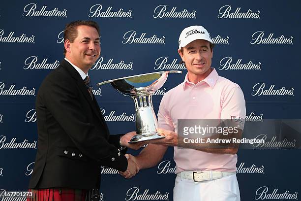 Brett Rumford of Australia poses with the trophy alongside James Maxwell, Regional Director Chivas Brothers Asia, after winning the Ballantine's...