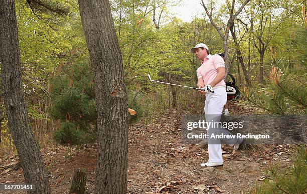 Brett Rumford of Australia plays from the trees on the 18th hole during the final round of the Ballantine's Championship at Blackstone Golf Club on...