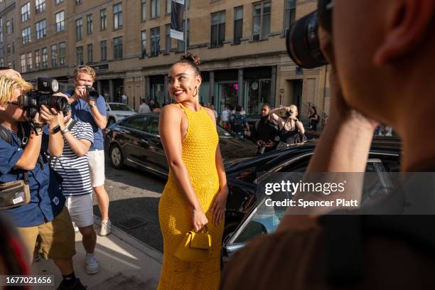 Woman attending Fashion Week poses before gets into a waiting car as photographers, models and members of the fashion industry gather outside of the...