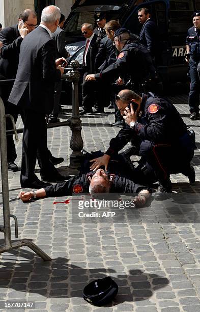 Policeman is helped after being shot by an apparently disturbed man, on April 28, 2013 in Rome, outside the palazzo Chigi, the Italian Prime minister...