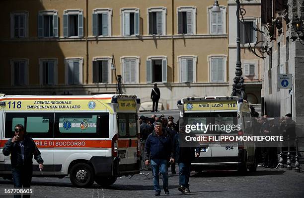 Two ambulance are parked near the area where a Carabiniere police officer was shot by an apparently disturbed man, on April 28, 2013 in Rome, outside...