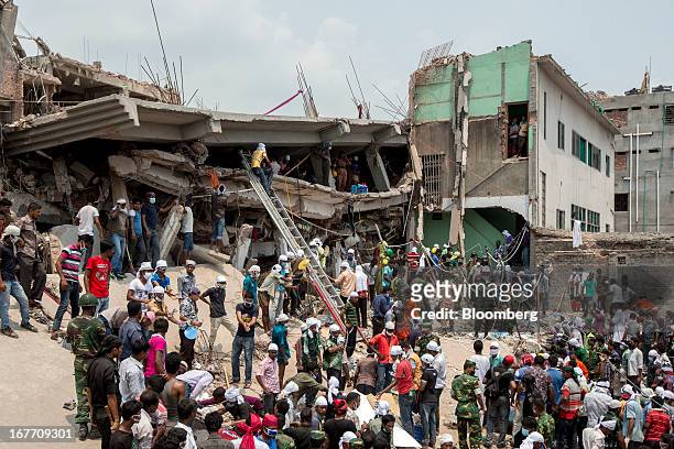 Rescue workers and volunteers search by hand for victims amongst the debris of the collapsed Rana Plaza building in Dhaka, Bangladesh, on Friday,...
