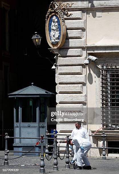 Carabinieri forensics officers work outside the Chigi Palace following a shooting in Rome, Italy, on Sunday, April 28, 2013. Two Italian police...