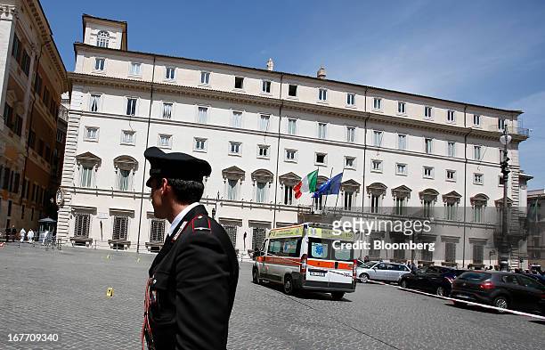 Carabinieri police officer stands on duty near an ambulance following a shooting outside the Chigi Palace in Rome, Italy, on Sunday, April 28, 2013....