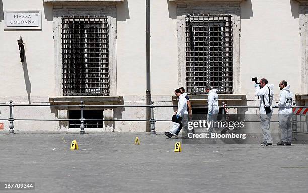 Police forensics officers work outside the Chigi Palace following a shooting in Rome, Italy, on Sunday, April 28, 2013. Two Italian police officers...