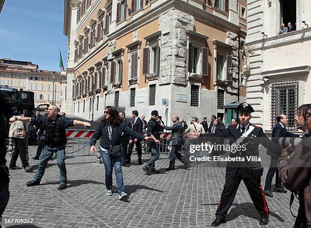 Italian police stand as they patrol around the area where gunshots were fired, in front of the Chigi Premier's office on April 28, 2013 in Rome,...