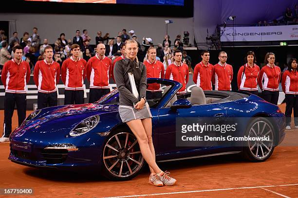 Maria Sharapova of Russia poses with her trophy, a blue Porsche 911 Carrera 4S Cabriolet after winning her final match against Na Li of China during...