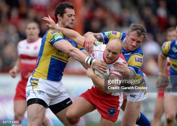 Michael Dobson of Hull KR is tackled by Ian Kirke and Jamie Peacock of Leeds during the Super League match between Hull Kingston Rovers and Leeds...
