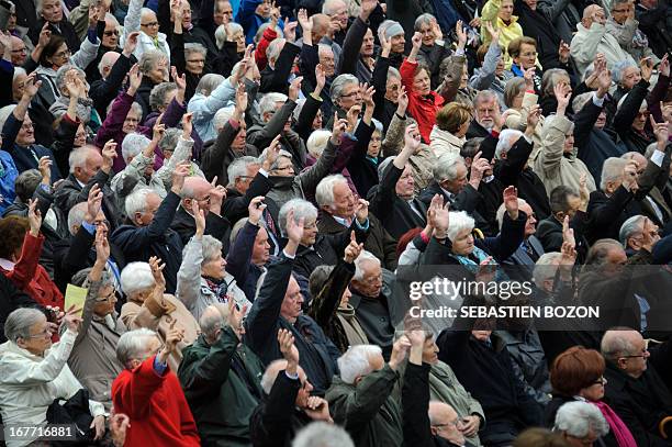 People raise their hands to vote during the annual Landsgemeinde meeting at a square in the town of Appenzell, eastern Switzerland on April 28, 2013....