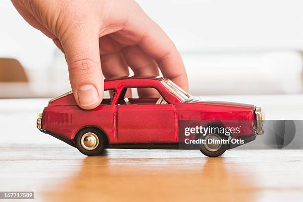 hand pushing vintage red toy car - toy car stock pictures, royalty-free photos & images