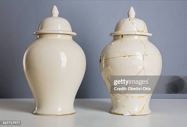 cream coloured vase next to broken, repaired one - vase stock-fotos und bilder