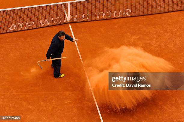 Staff member throws clay on the court during the final match of day seven of the 2013 Barcelona Open Banc Sabadell on April 28, 2013 in Barcelona....