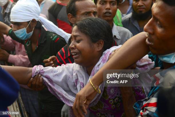 Bangladeshi relatives react after looking at the coffin of a victim following the collapse of the Rana Plaza garment building in Savar, on the...