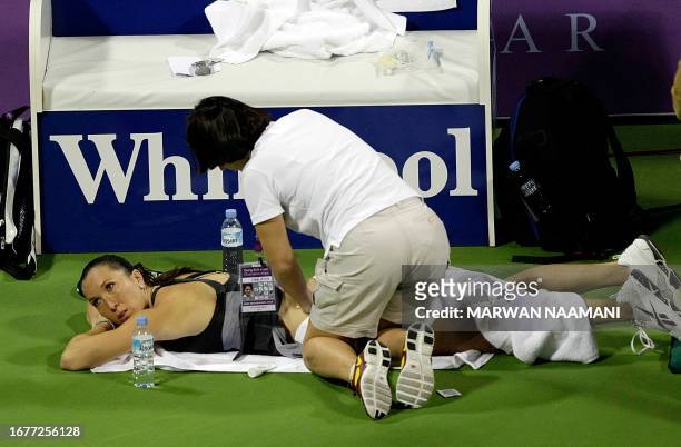 Serbian top-seeded tennis player Jelena Jankovic receives treatment during her match against Russian Svetlana Kuznetsova at their season-ending WTA...