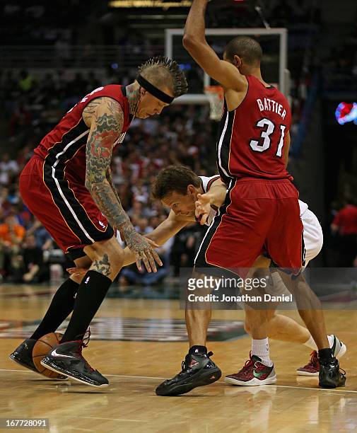 Mike Dunleavy of the Milwaukee Bucks looses control of the ball between Chris Anderson and Shane Battier of the Miami Heat in Game Four of the...