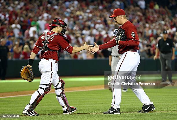 Relief pitcher J.J. Putz of the Arizona Diamondbacks shakes hands with catcher Miguel Montero after defeating the Colorado Rockies 4-2 in the MLB...