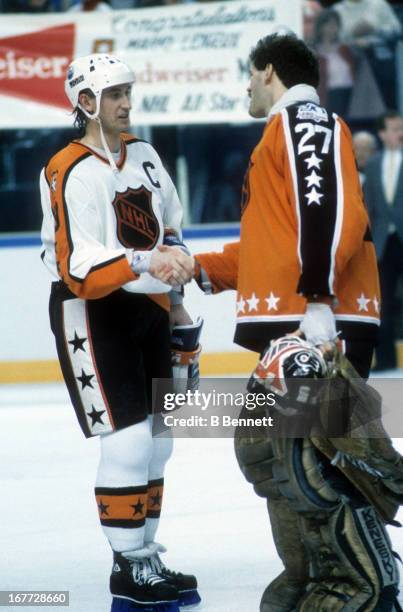 Goalie Ron Hextall of the Wales Conference and the Philadelphia Flyers shakes hands with Wayne Gretzky of the Campbell Conference and the Edmonton...