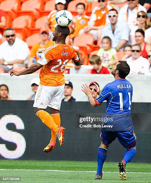 Corey Ashe of the Houston Dynamo heads the ball away from Brian Mullan of the Colorado Rapids at BBVA Compass Stadium on April 28, 2013 in Houston,...