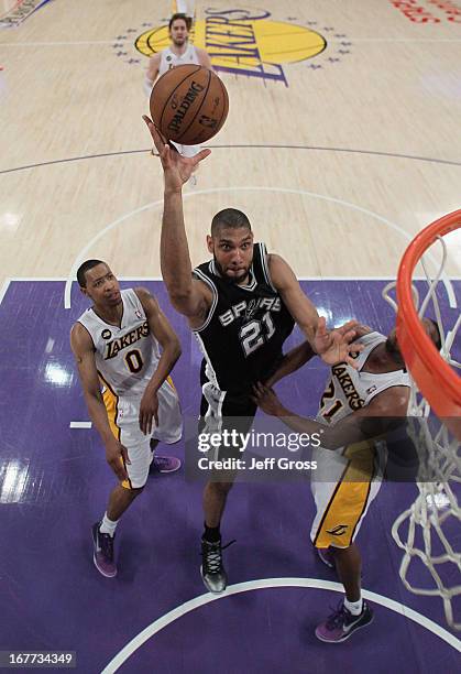 Tim Duncan of the San Antonio Spurs drives to the basket between Andrew Goudelock and Chris Duhon of the Los Angeles Lakers in the first half during...