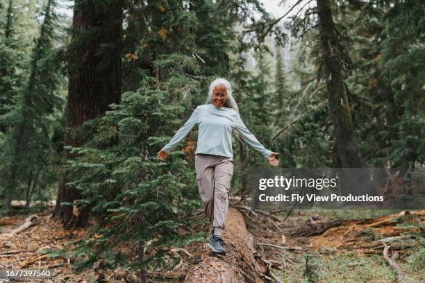 active senior woman balances on fallen tree - oregon amerikaanse staat stockfoto's en -beelden