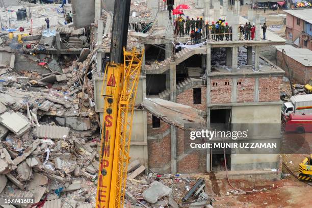 Bangladeshi rescuers work as Bangladeshi Army personel begin the second phase of the rescue operation using heavy equipment after an eight-storey...