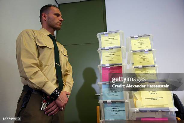 Police officer stands next to a lottery box during the media conference following the lottery draw for the 50 media spots inside the courtroom for...