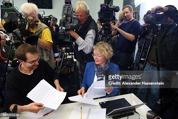 Journalists read the press statement of the Oberlandgericht Muenchen court during a press conference after the the lottery draw for the 50 media...