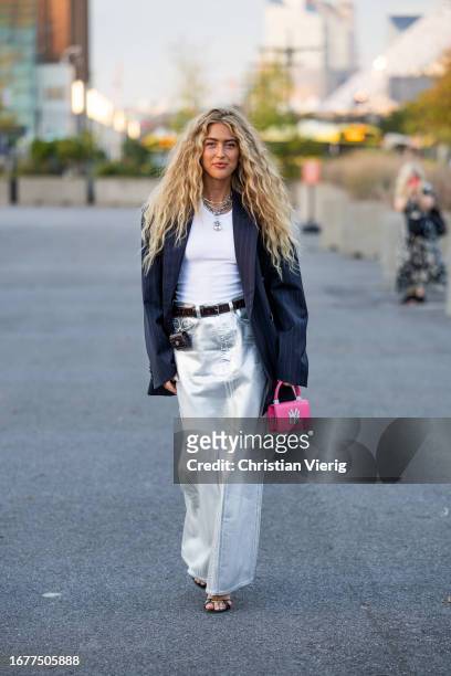 Emili Sindlev wears silver white skirt, black blazer, pink bag, white shirt wears outside COS on September 12, 2023 in New York City.