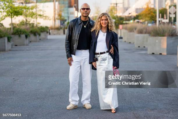 Couple Mads Emil & Emili Sindlev wears silver white skirt, black blazer, pink bag, white shirt wears outside COS on September 12, 2023 in New York...