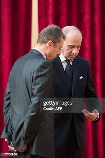 French Minister of Foreign Affairs Laurent Fabius speaks with General Director of External Security Bernard Bajolet prior to a meeting with France's...