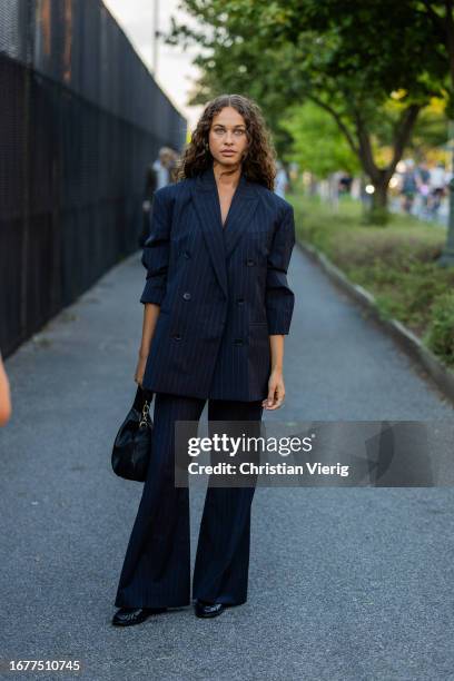 Sarah Lysander wears oversized navy double breasted blazer, pants, suit, black bag outside COS on September 12, 2023 in New York City.