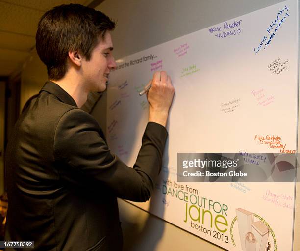Joe Harrison, one of the event coordinators, signs a card backstage for Jane Richard, during a benefit called "Dance Out For Jane," held at the John...