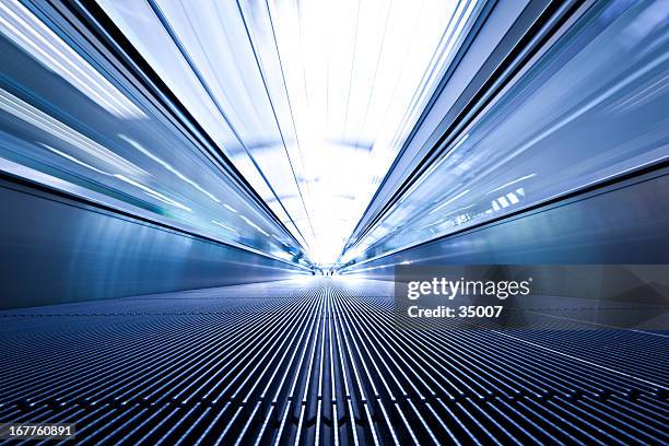 blue toned low angle photo of moving walkway - zooming stockfoto's en -beelden