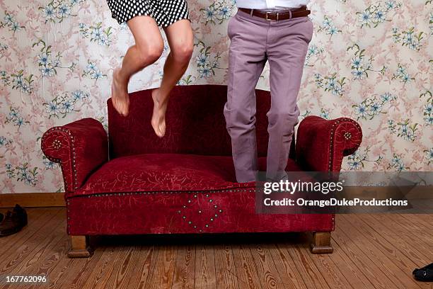 young couple jumping on old school couch - foot worship 個照片及圖片檔