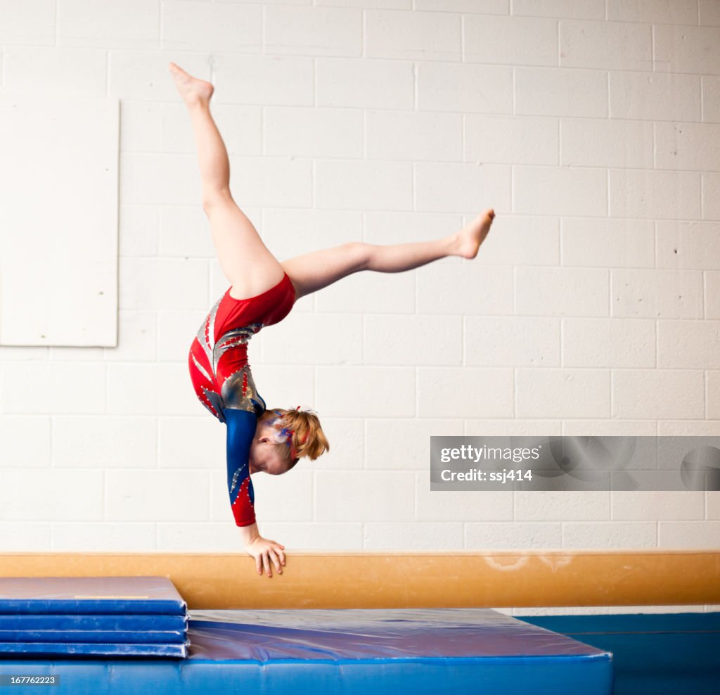 Kleine Turnerin Performing Walkover auf Balance Beam