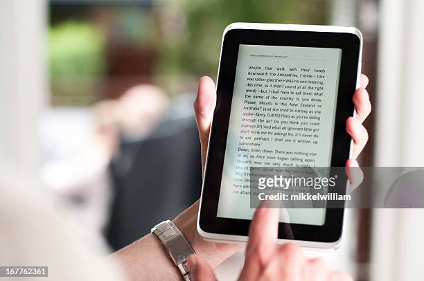 reading ebook on a small digital tablet - e reader stock pictures, royalty-free photos & images