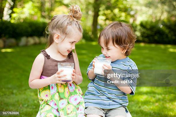 due piccoli ragazzi bere latte e all'aperto - drink milk foto e immagini stock